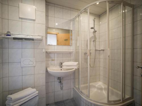 a white bathroom with a shower and a sink at Apartment Erich Brixen in Brixen im Thale