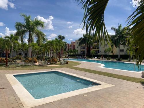 una piscina en un complejo con palmeras en VIP Home en Santiago de los Caballeros