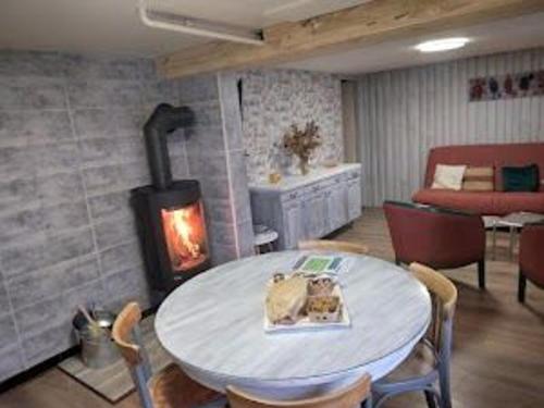 - un salon avec une table et un poêle à bois dans l'établissement Gîte Paisible au Cœur de la Forêt, Idéal pour 4 Pers avec Terrasse, Jardin et Activités Nature - FR-1-589-322, à La Bourgonce