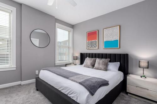 a bedroom with a large bed and two windows at Soaring 2-Bedroom Parkside Loft Walkable to it All in Cincinnati