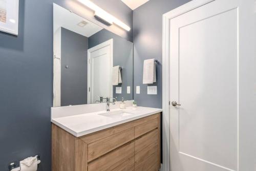 La salle de bains est pourvue d'un lavabo et d'un miroir. dans l'établissement Soaring 2-Bedroom Parkside Loft Walkable to it All, à Cincinnati