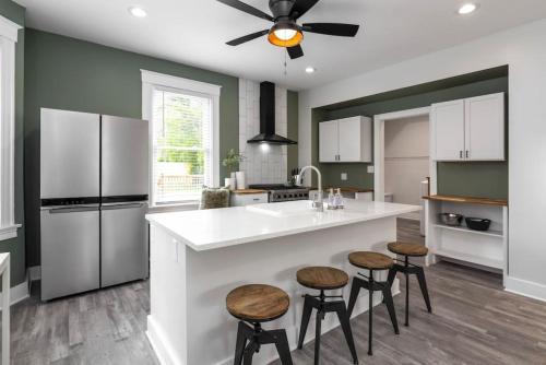 een keuken met een wit aanrecht en krukken bij Deluxe 4-Bedroom w Huge Deck 3-Min to Downtown in Cincinnati