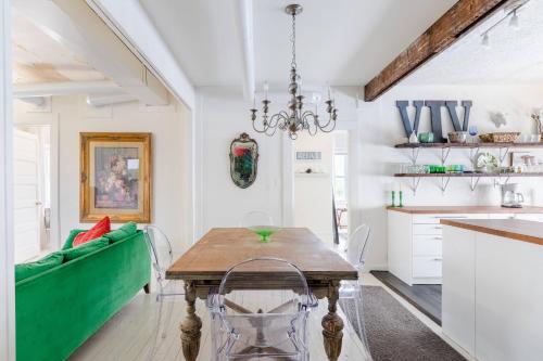 a dining room with a table and a green couch at Boutique Apartment in 1905 Victorian Home - Plaza - Westport in Kansas City