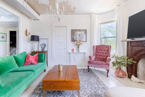 a living room with a green couch and a table at Boutique Apartment in 1905 Victorian Home - Plaza - Westport in Kansas City