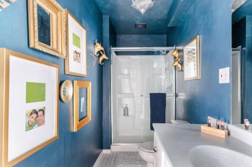 a blue bathroom with a toilet and a shower at Boutique Apartment in 1905 Victorian Home - Plaza - Westport in Kansas City