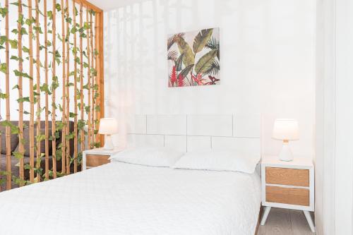 a white bedroom with a bed and two lamps at Apartamento Loft Edificio Soho 906 in Armenia