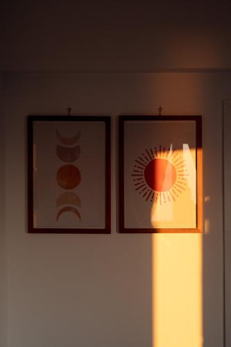 two framed pictures on a wall next to a lamp at Lena Magda B&B in Furore