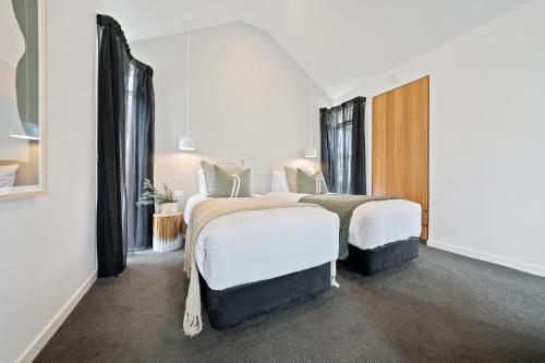 2 camas en una habitación con 2 ventanas en Hepburn Spa Retreat en Hepburn Springs