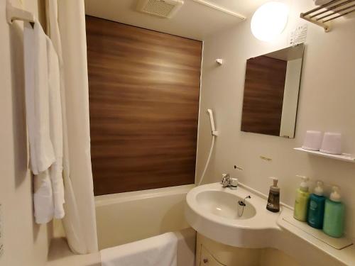 a bathroom with a sink and a toilet and a mirror at Hotel Route-Inn Kameyama Inter in Kameyama