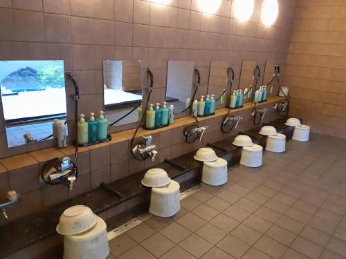 een openbare badkamer met een rij wastafels en toiletten bij Hotel Route-Inn Kameyama Inter in Kameyama