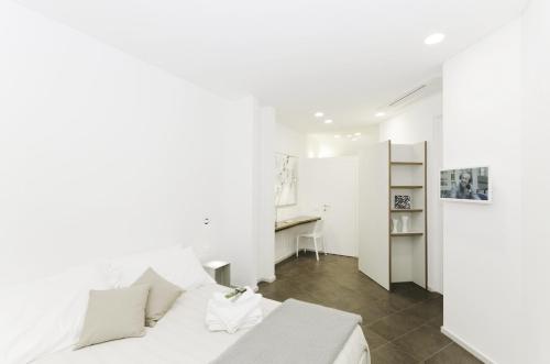 a white bedroom with a bed and a desk at Genova Porto Antico Boutique Rooms in Genoa