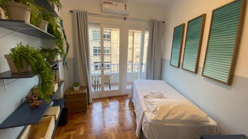 a small room with a bed and a balcony at Apartamento encantador em prédio histórico in Santos