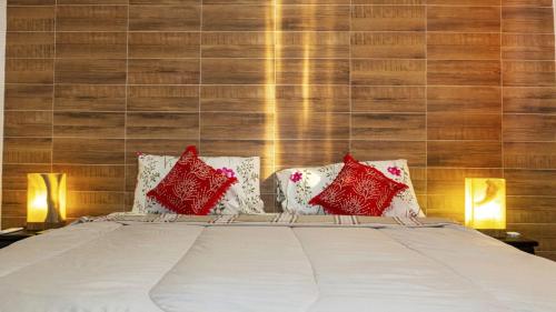 - une chambre avec un lit doté d'oreillers rouges et blancs dans l'établissement Hotel boutique CVC, à Acapulco