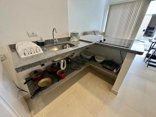 a kitchen with a sink and a counter with pots and pans at Vila Capilano Ubatuba in Ubatuba