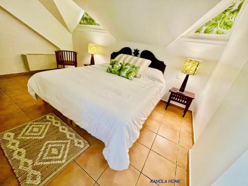 a bedroom with a white bed with green pillows at KANOLA Home in Sainte-Anne