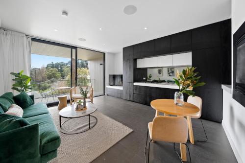 a living room with a green couch and a table at Hepburn Bathhouse & Spa Villas in Hepburn Springs