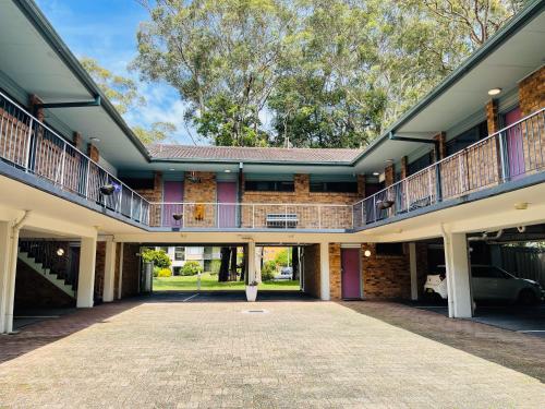 an empty courtyard of a house with a balcony at Port Stephens Motel in Nelson Bay