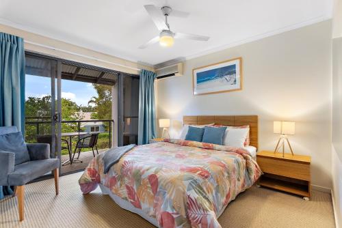 a bedroom with a bed and a balcony at North Facing, 2 bedroom Townhouse in Tropical Resort in Noosaville