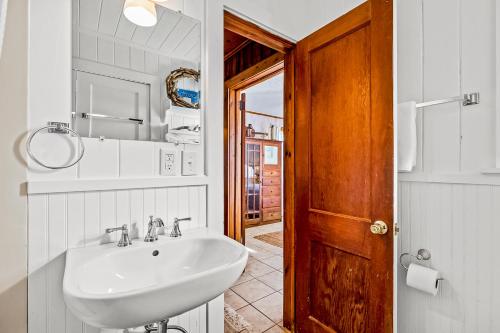 a bathroom with a sink and a wooden door at Charming Cottage in Atlantic Beach