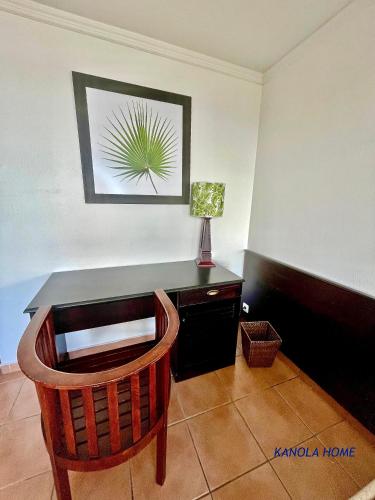 a desk with a chair and a lamp in a room at KANOLA Home in Sainte-Anne
