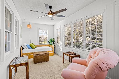 uma sala de estar com uma cadeira rosa e uma cama em Charming Cottage em Atlantic Beach