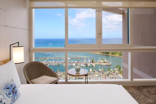 a bedroom with a large window with a view of a harbor at Prince Waikiki in Honolulu