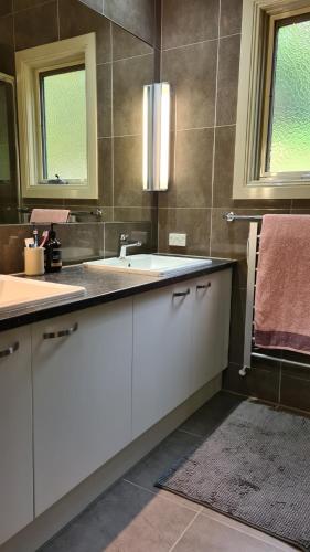 a bathroom with white cabinets and a sink at Woodbine Lodge in Marysville