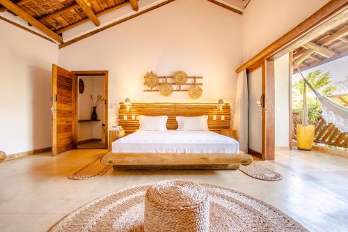 a bedroom with a bed with a wooden headboard at VillaMag in Jericoacoara
