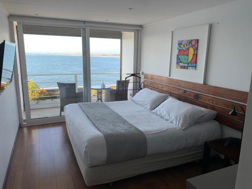 a bedroom with a bed with a view of the ocean at Laura del Mar Hotel Boutique in Concón