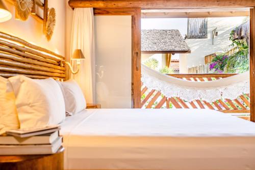 a bedroom with a bed and a window at VillaMag in Jericoacoara