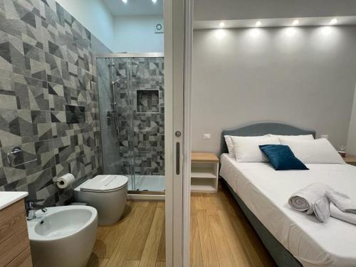 a bathroom with a bed and a shower and a sink at Nike Luxury Rooms in Agrigento