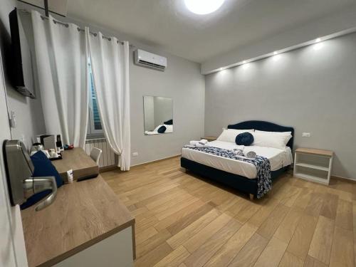 a bedroom with a bed and a desk and a television at Nike Luxury Rooms in Agrigento