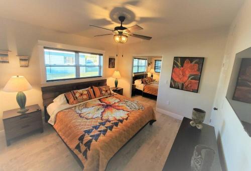 a bedroom with a large bed and a ceiling fan at Bali Bungalow - Downtown Cocoa Beach in Cocoa Beach