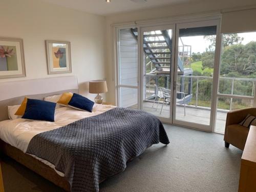 a bedroom with a bed and a large window at Broadbeach Inverloch in Inverloch