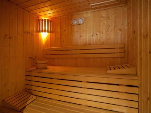 a wooden sauna with a bench and a light in it at Le Paquis in Tignes