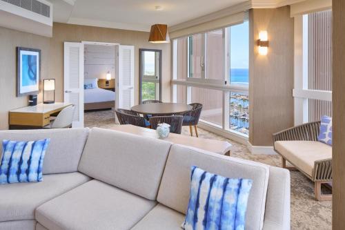 a living room with a couch and a room with a view of the ocean at Prince Waikiki in Honolulu