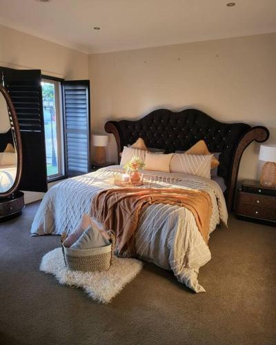 sypialnia z dużym łóżkiem i dużym lustrem w obiekcie Luxury Green w mieście Greenvale