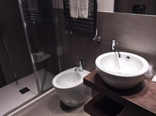 a bathroom with a white sink and a shower at Hotel Ariston & Apartments in Varazze
