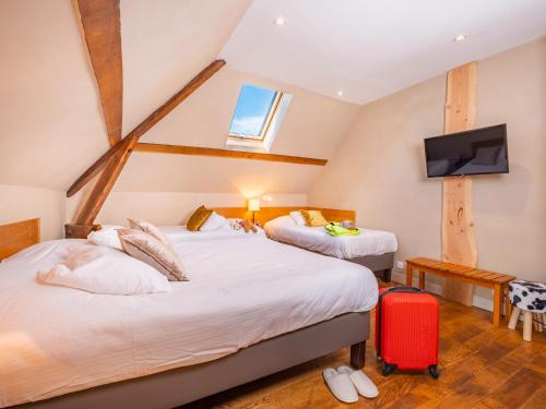 two beds in a room with a red suitcase at Le Relais des Lacs Bourgogne Morvan in Planchez