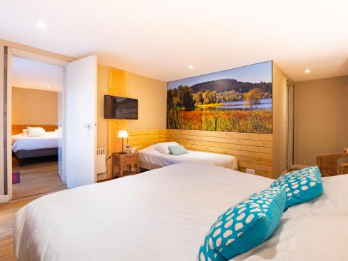 a hotel room with two beds and a painting on the wall at Le Relais des Lacs Bourgogne Morvan in Planchez