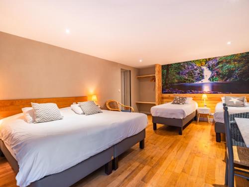 a hotel room with two beds and a large painting on the wall at Le Relais des Lacs Bourgogne Morvan in Planchez