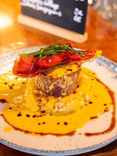 a plate with a dish of food on a table at Le Relais des Lacs Bourgogne Morvan in Planchez