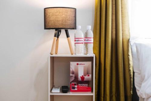 a lamp on a night stand next to a bed at RedDoorz at EM Pensiontel Butuan City in Butuan