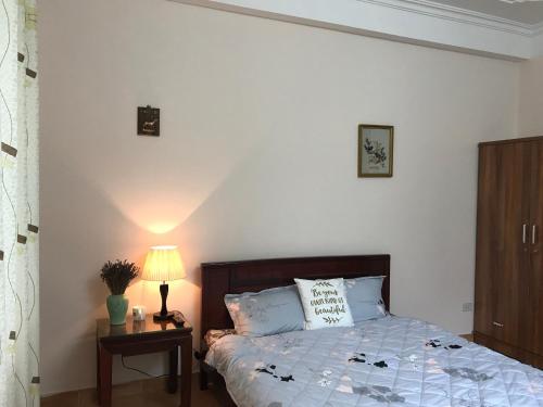 a bedroom with a bed and a lamp on a table at 105 Láng Hạ in Hanoi