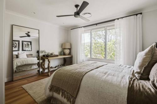 a bedroom with a bed and a large window at Dunes on Sandy Wha in Gerringong