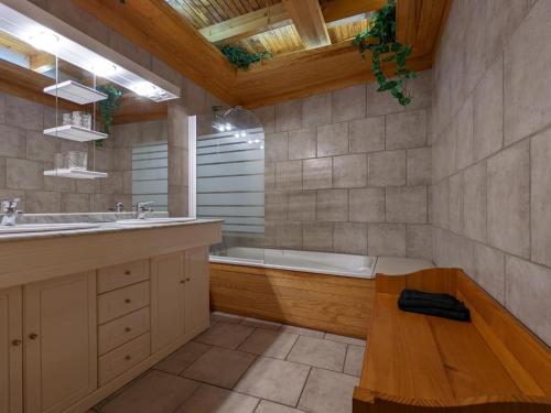 ein Badezimmer mit einer Badewanne, einem Waschbecken und einer Bank in der Unterkunft Gîte Charras, 5 pièces, 6 personnes - FR-1-653-7 in Charras