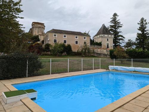 une grande piscine bleue devant une maison dans l'établissement Gîte Charentais avec Piscine Chauffée, Jardin, Equip. Bébé et Recharge Électrique - Proche Périgord - FR-1-653-7, à Charras