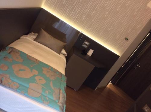 a small bedroom with a bed with a light on it at Hotel Ariston & Apartments in Varazze