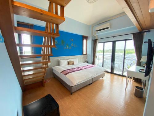 吉安的住宿－晨曦農業休閒民宿 ，一间设有床铺的卧室,位于一间拥有蓝色墙壁的房间