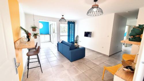 a living room with a blue couch and a table at Le Marie-Agnès Appartement neuf de Standing in Fort-de-France